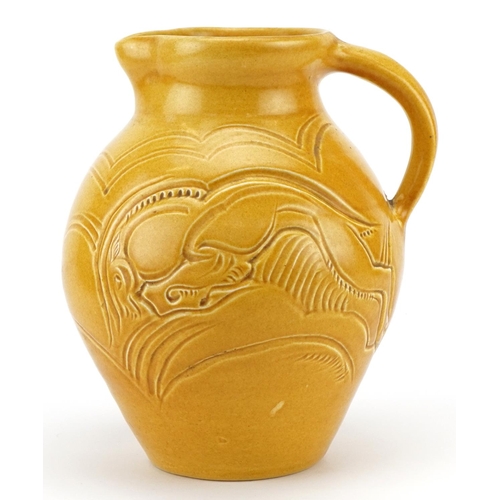 328 - Early 20th century Susie Cooper green glazed jug incised with two stylised leaping deer, 22cm high