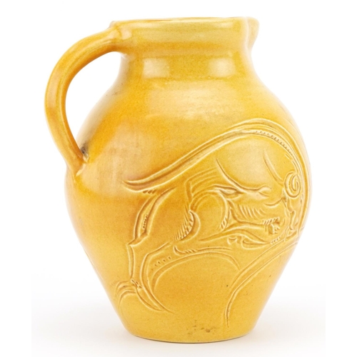 328 - Early 20th century Susie Cooper green glazed jug incised with two stylised leaping deer, 22cm high