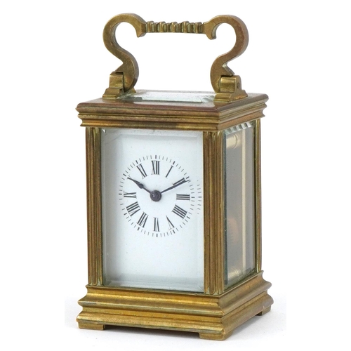 301 - Miniature brass cased carriage clock with case, the circular dial having Roman numerals, the carriag... 