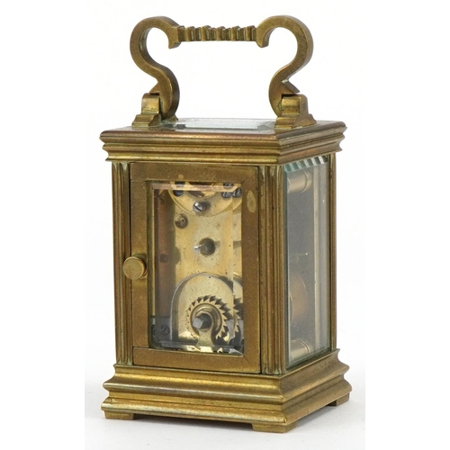 301 - Miniature brass cased carriage clock with case, the circular dial having Roman numerals, the carriag... 