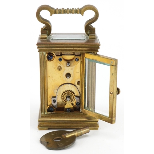 301 - Miniature brass cased carriage clock with case, the circular dial having Roman numerals, the carriag... 