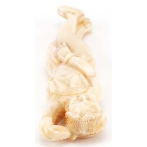 2467 - Scrimshaw style bone carving of a reclining nude female, 13.5cm in length