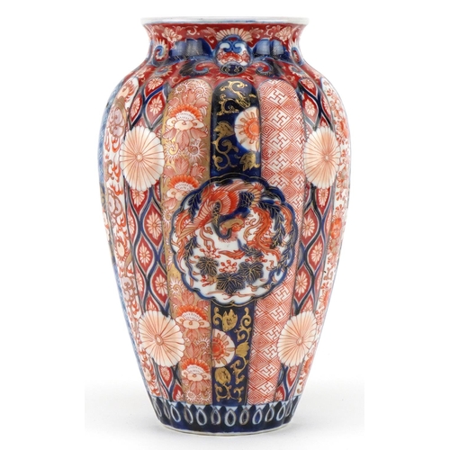 196 - Japanese Imari porcelain fluted vase hand painted with flowers and stylised roundels enclosing phoen... 