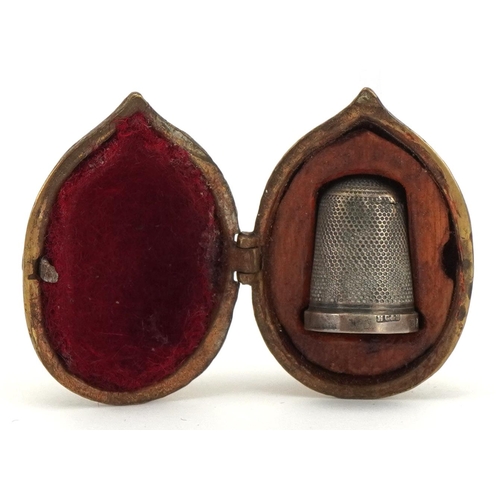 705 - Victorian brass thimble case in the form of an acorn housing a silver thimble, the case 4.5cm high