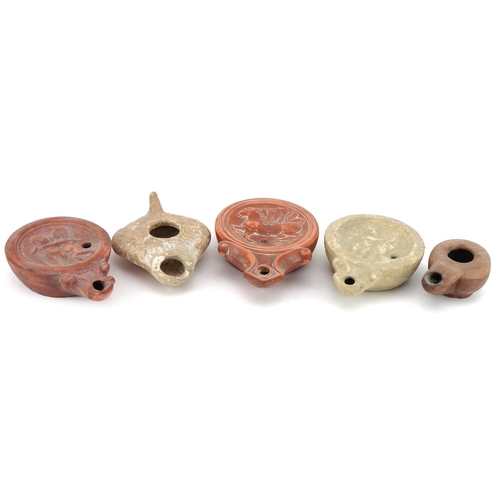 419 - Five Roman style terracotta and pottery oil lamps, the largest 11.5cm in length