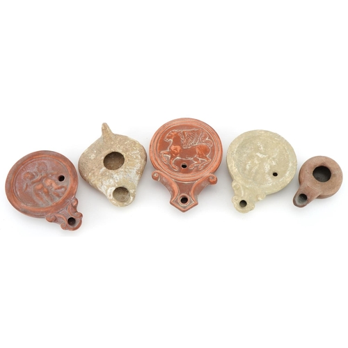 419 - Five Roman style terracotta and pottery oil lamps, the largest 11.5cm in length