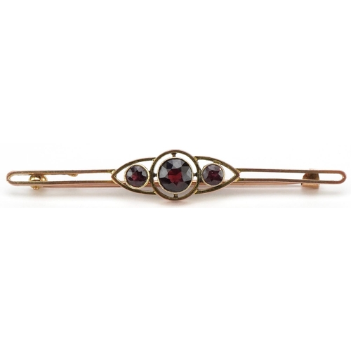 3164 - 9ct gold garnet three stone openwork bar brooch, 6.5cm wide, 4.2g