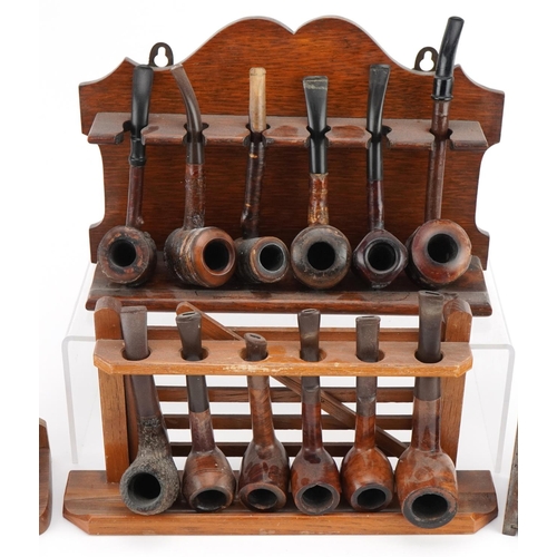 1298 - Twenty vintage briar tobacco smoking pipes arranged in four pipe racks, one in the form of a gate, i... 