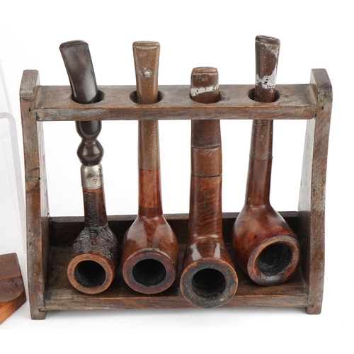 1298 - Twenty vintage briar tobacco smoking pipes arranged in four pipe racks, one in the form of a gate, i... 