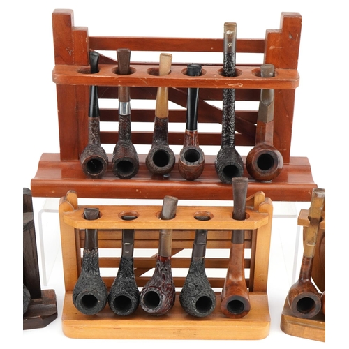 1273 - Nineteen vintage briar tobacco smoking pipes, some Italian, arranged in four pipe racks, three in th... 