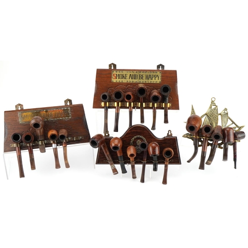 1282 - Twenty two vintage briar tobacco smoking pipes arranged in four wall hanging pipe racks, two with Sm... 