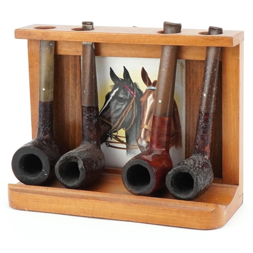 1260 - Four Dunhill briar tobacco smoking pipes arranged in a pipe rack, comprising three Shell and one Bru... 