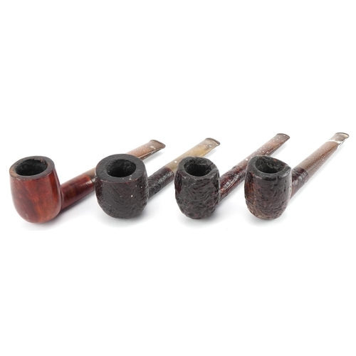 1260 - Four Dunhill briar tobacco smoking pipes arranged in a pipe rack, comprising three Shell and one Bru... 