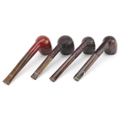 1260 - Four Dunhill briar tobacco smoking pipes arranged in a pipe rack, comprising three Shell and one Bru... 