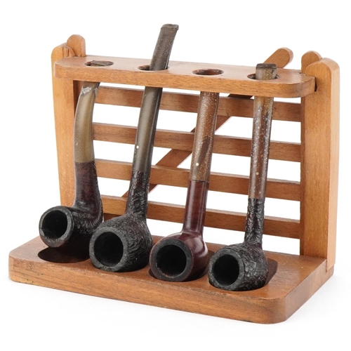 1258 - Four Dunhill briar tobacco smoking pipes arranged in a gate design pipe rack including Shell briar, ... 