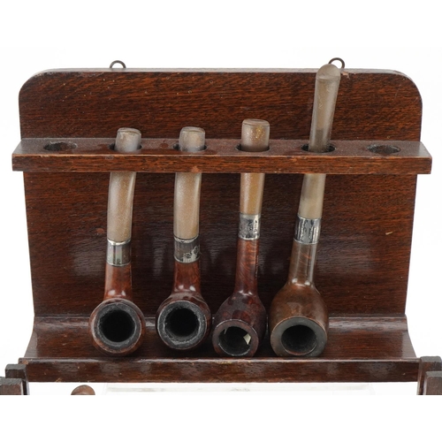 1280 - Thirteen vintage Peterson's briar tobacco smoking pipes, four with silver collars, arranged in three... 