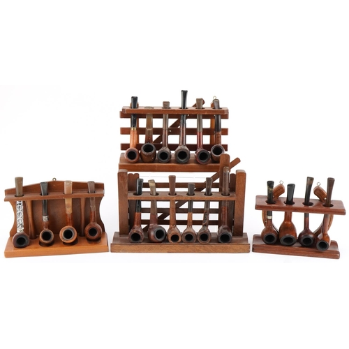 1289 - Twenty vintage tobacco smoking pipes, predominantly briar, arranged in four pipe racks comprising th... 