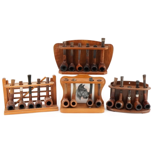 1299 - Twenty vintage briar tobacco smoking pipes, one with silver collar, arranged in four pipe racks, one... 