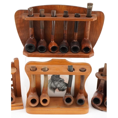 1299 - Twenty vintage briar tobacco smoking pipes, one with silver collar, arranged in four pipe racks, one... 