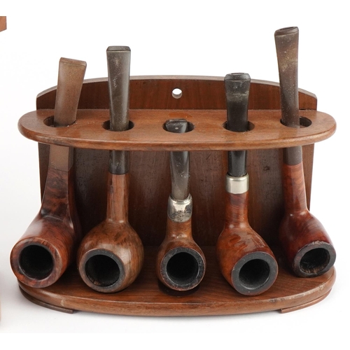 1299 - Twenty vintage briar tobacco smoking pipes, one with silver collar, arranged in four pipe racks, one... 