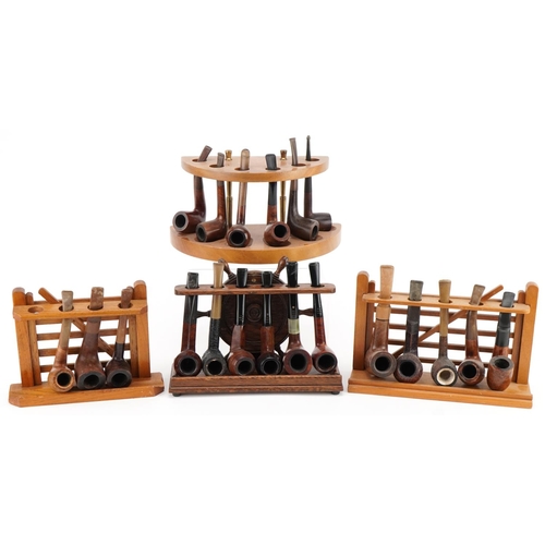 1300 - Twenty one vintage briar tobacco smoking pipes arranged in four pipe racks including an oak ship's w... 