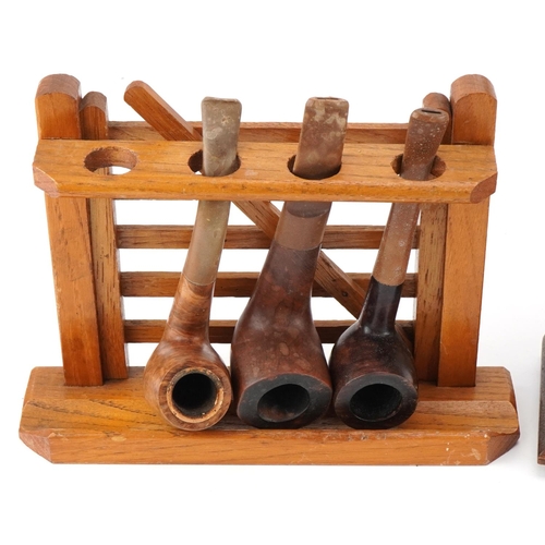 1300 - Twenty one vintage briar tobacco smoking pipes arranged in four pipe racks including an oak ship's w... 