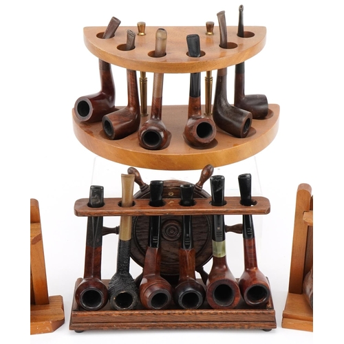 1300 - Twenty one vintage briar tobacco smoking pipes arranged in four pipe racks including an oak ship's w... 