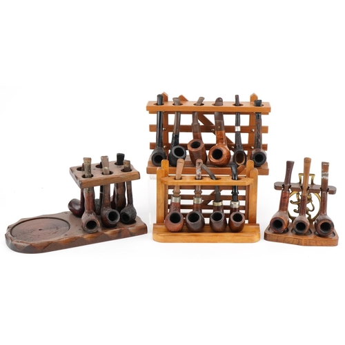 1293 - Nineteen vintage tobacco smoking pipes, predominantly briar, arranged in four pipe racks, two in the... 