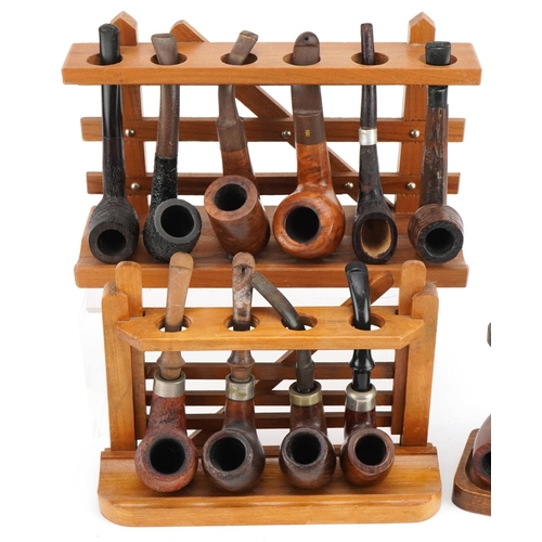 1293 - Nineteen vintage tobacco smoking pipes, predominantly briar, arranged in four pipe racks, two in the... 