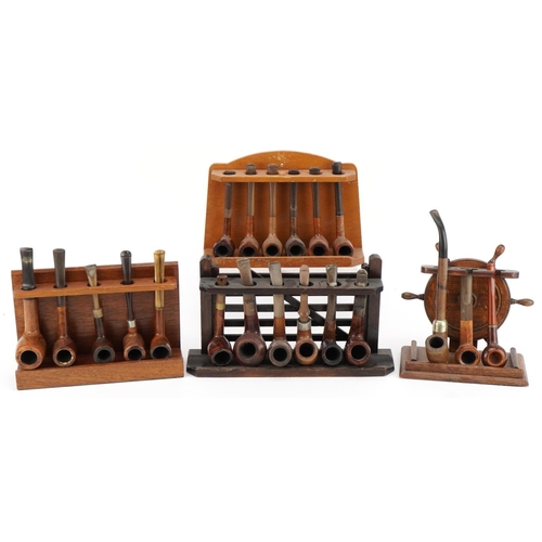 1279 - Twenty vintage briar tobacco smoking pipes arranged in four pipe racks including an oak example in t... 