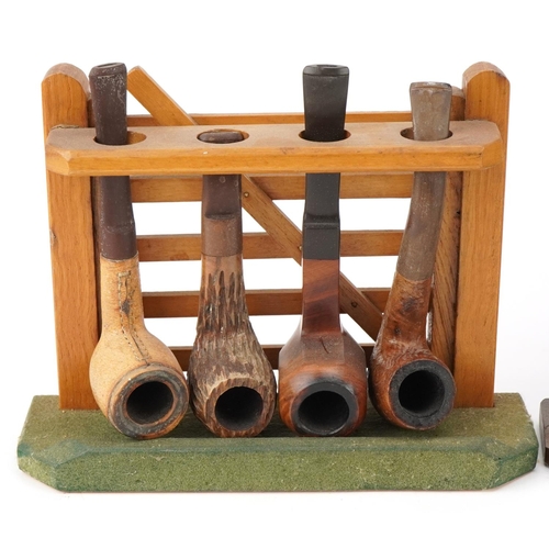 1290 - Twenty vintage briar tobacco smoking pipes arranged in four pipe racks including three in the form o... 