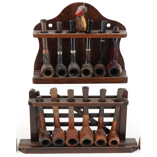 1290 - Twenty vintage briar tobacco smoking pipes arranged in four pipe racks including three in the form o... 