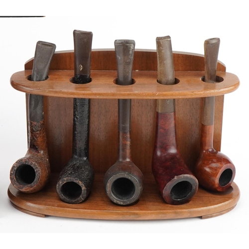 1277 - Twenty vintage briar tobacco smoking pipes arranged in four pipe stands including one in the form of... 