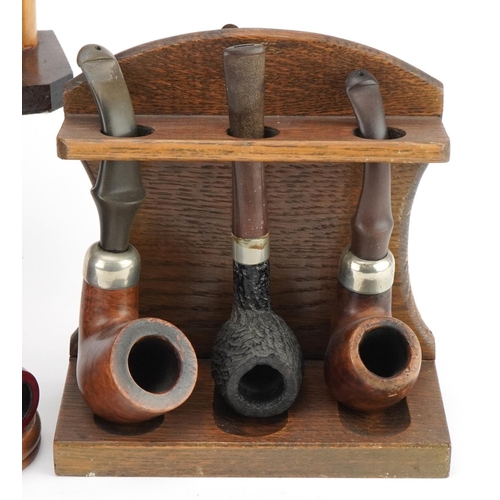 1292 - Twenty vintage tobacco smoking pipes, predominantly briar arranged in four pipe racks including one ... 