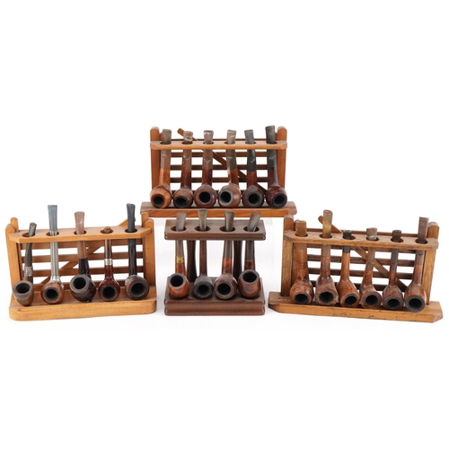 1278 - Twenty vintage briar tobacco smoking pipes , one with silver mount, arranged in four pipe racks, inc... 