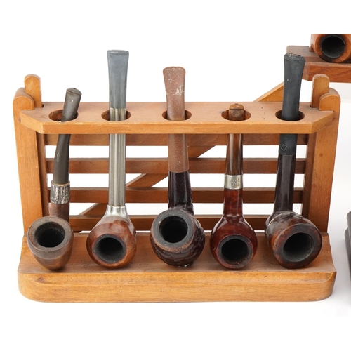 1278 - Twenty vintage briar tobacco smoking pipes , one with silver mount, arranged in four pipe racks, inc... 