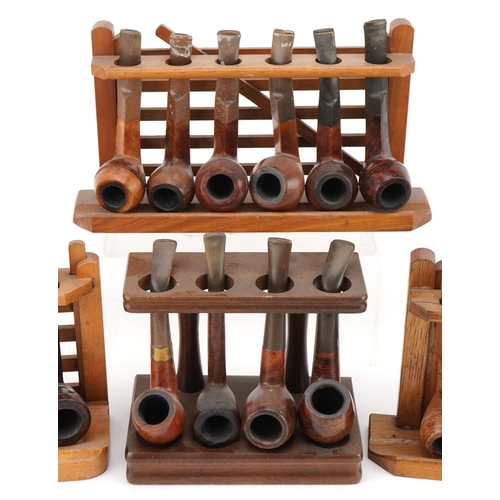 1278 - Twenty vintage briar tobacco smoking pipes , one with silver mount, arranged in four pipe racks, inc... 