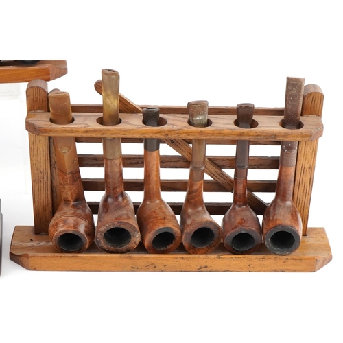 1278 - Twenty vintage briar tobacco smoking pipes , one with silver mount, arranged in four pipe racks, inc... 