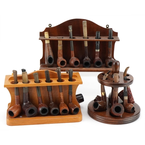 1270 - Twenty four briar tobacco smoking pipes arranged in three pipe racks including a double sided exampl... 