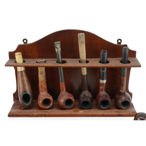 1270 - Twenty four briar tobacco smoking pipes arranged in three pipe racks including a double sided exampl... 