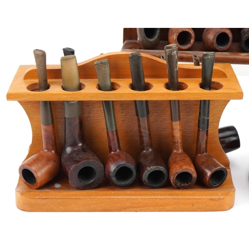 1270 - Twenty four briar tobacco smoking pipes arranged in three pipe racks including a double sided exampl... 