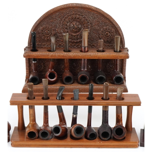 1276 - Twenty two vintage tobacco smoking pipes, predominantly briar, arranged in four pipe racks including... 