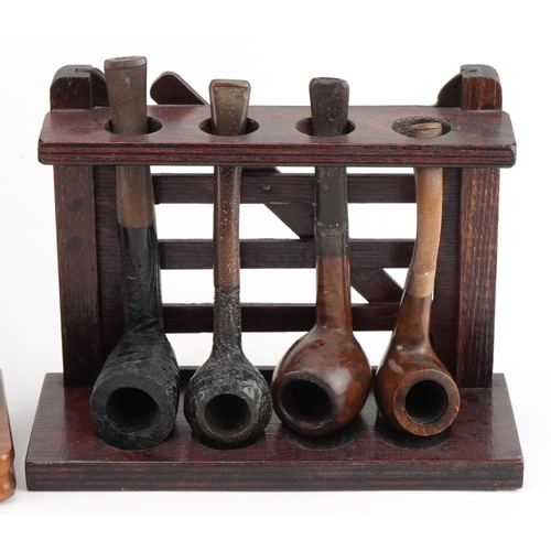 1276 - Twenty two vintage tobacco smoking pipes, predominantly briar, arranged in four pipe racks including... 