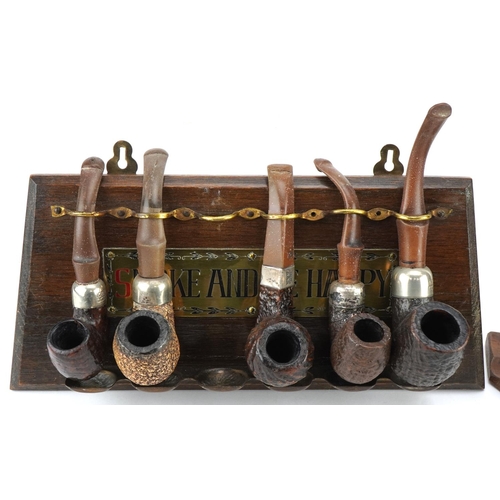 1274 - Eleven vintage Peterson's briar tobacco smoking pipes arranged in two pipe racks comprising one in t... 