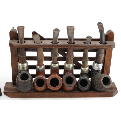 1274 - Eleven vintage Peterson's briar tobacco smoking pipes arranged in two pipe racks comprising one in t... 