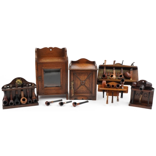 1320 - Sixteen vintage tobacco smoking pipes, predominantly briar, and two oak smoker's cabinets, the pipes... 