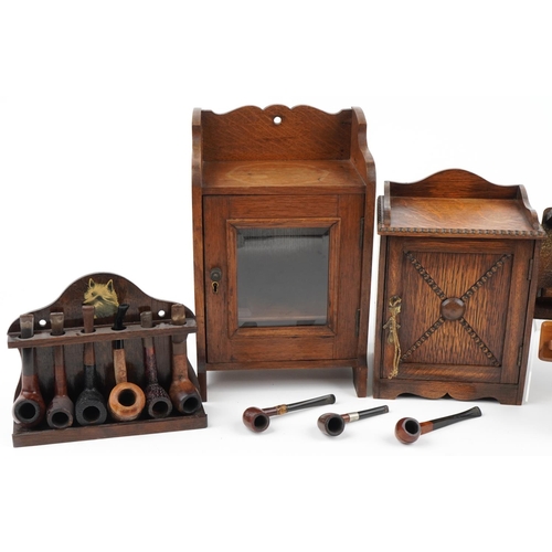 1320 - Sixteen vintage tobacco smoking pipes, predominantly briar, and two oak smoker's cabinets, the pipes... 