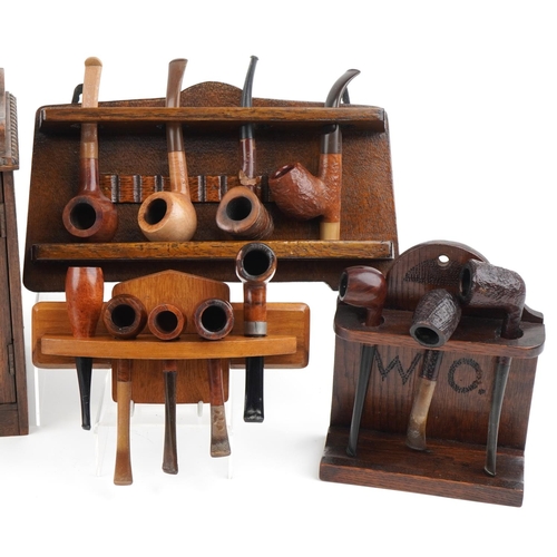 1320 - Sixteen vintage tobacco smoking pipes, predominantly briar, and two oak smoker's cabinets, the pipes... 