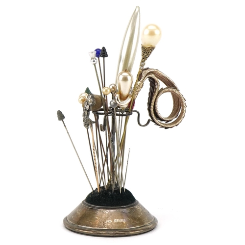 622 - Silver hatpin stand housing various hatpins including simulated pearl and sequinned examples, the st... 