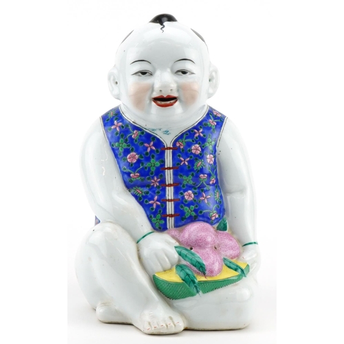 522 - Chinese porcelain figure of a young boy holding fruit, 30cm high